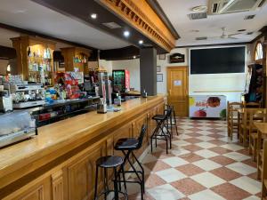 a bar in a restaurant with bar stools at Hotel-Restaurante la Loma in Baeza
