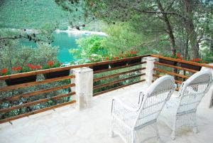 two chairs on a patio with a view of a lake at Hotel Art Media in Herceg-Novi