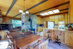 cocina y comedor con una gran mesa de madera en Mountain and River View Cliff House, en Graeagle