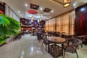 a restaurant with tables and chairs and plants at Hotel Shanghai City in Osh
