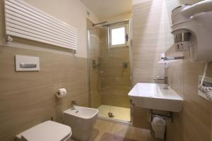 a bathroom with a toilet and a sink and a shower at Hotel Villa Margherita in Quercianella