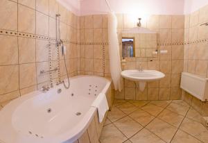 baño grande con bañera y lavamanos en Hotel Garden en Bolesławiec