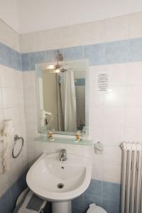 bagno con lavandino e specchio di Hotel Alexandros a Volos