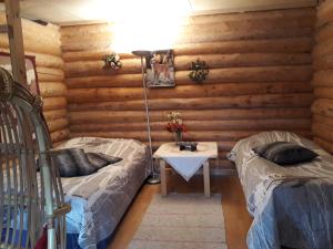 ein Zimmer mit zwei Betten und einem Tisch darin in der Unterkunft Kinkamon Pirtti in Keuruu