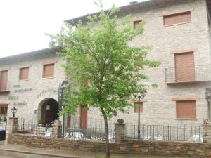 a building with a tree in front of it at Villa Maria in La Virgen de la Vega