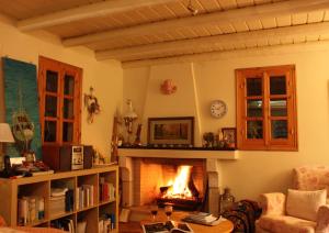 a fireplace in a living room with a fire place at Mercouri stone cottage in Korakokhórion