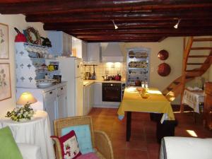 a kitchen with a table with a yellow table cloth at Mercouri stone cottage in Korakokhórion