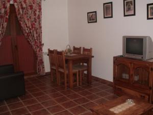 a living room with a table and a television at Villa Maria in La Virgen de la Vega