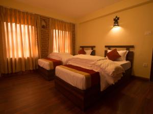 Giường trong phòng chung tại HOTEL LAYAKU DURBAR