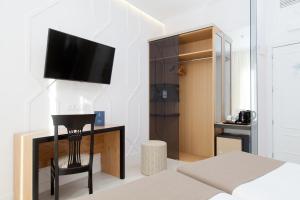 1 dormitorio con 1 cama y TV en la pared en Hotel Europa, en Madrid
