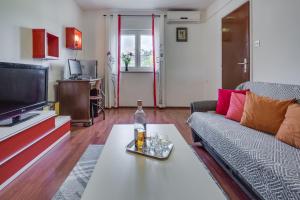 een woonkamer met een bank en een fles op een tafel bij Apartments Grancarić in Zadar