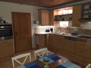 una cocina con armarios de madera, mesa y sillas en Ferienhaus Linn, en Hohenau