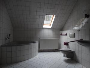 a bathroom with a tub and a toilet and a sink at Ferienwohnung Franke DG RuheZeit am Schwarzwasser in Johanngeorgenstadt
