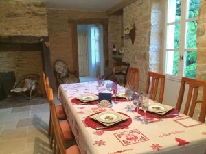 a dining room with a table with plates and wine glasses at Domaine de Galoubet Lot in Beaumat