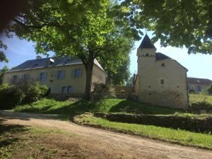 an old building with a tower and a tree at Domaine de Galoubet Lot in Beaumat
