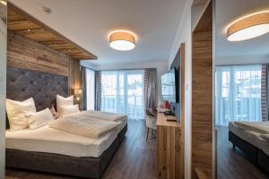 um quarto de hotel com uma cama grande e uma secretária em Hotel Eldorado em Ischgl