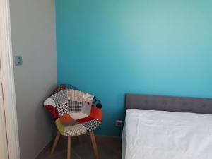 sypialnia z kolorowym krzesłem obok łóżka w obiekcie Petite suite sympa Avoine w mieście Avoine