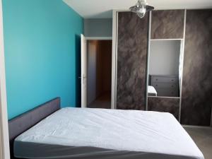 1 dormitorio con cama blanca y espejo en Petite suite sympa Avoine, en Avoine