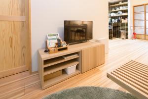 a living room with a television on a wooden cabinet at MACHIYA de HIGASHIYAMA in Kyoto