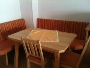 a wooden table and chairs with a napkin on it at Haus König in Obergurgl