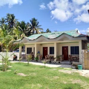 ein kleines Haus mit grünem Dach in der Unterkunft Enrico's Guesthouse in Siquijor