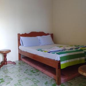 a bed in a room with a wooden frame at Enrico's Guesthouse in Siquijor