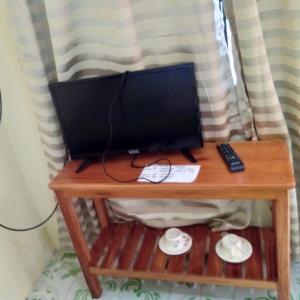 a computer monitor on a table with a remote control at Enrico's Guesthouse in Siquijor