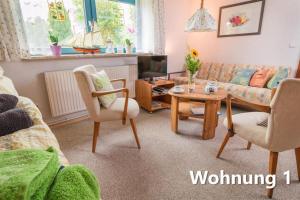 una sala de estar con un sofá y una mesa en Ferienwohnung Küssner, en Kiel