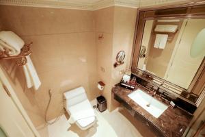 a bathroom with a toilet a sink and a mirror at LK Emerald Beach - SHA Extra Plus in Pattaya North