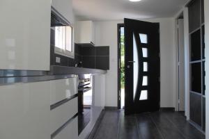 a kitchen with white walls and a black door at Charmante Villa à 15 min de Nice avec piscine in Blausasc