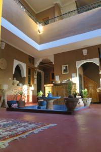 una sala de estar con una gran sala con mesas y jarrones en Kasbah du Bout du Monde, en Zagora