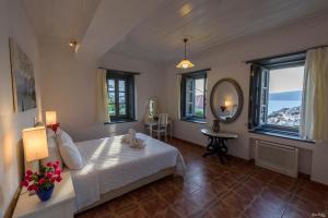 a bedroom with a bed and a mirror and windows at KK Houses in Hydra