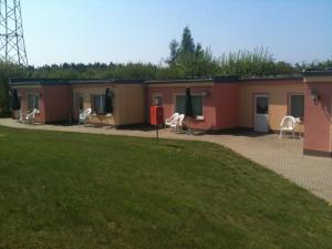 a row of mobile homes with chairs in a yard at Hotel-Pension Am Mühlberg in Lübbenau