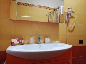 a bathroom with a white sink and a mirror at B&B Domus Traiani Benevento in Benevento
