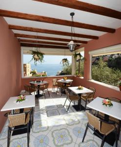 a restaurant with tables and chairs and a view of the ocean at Villa Maria Antonietta in Positano