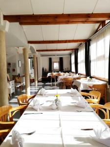 ein Esszimmer mit weißen Tischen und Stühlen in der Unterkunft Gasthof Falkeis in Kauns