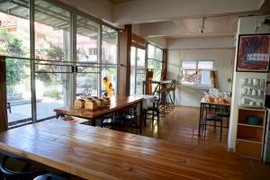 a dining room with tables and chairs and windows at Tourist Inn in Chiang Rai