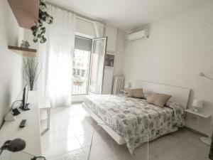 a white bedroom with a bed and a window at Residenza Riva Reno - BOLOGNA in Bologna