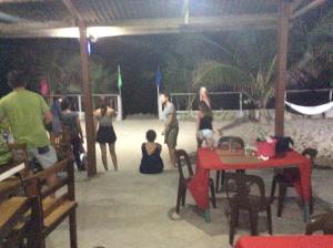 un grupo de personas de pie alrededor de una mesa en un pabellón en Bucana beachfront guesthouse, en El Nido