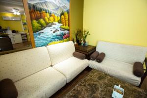 a living room with two white couches and a painting at Songhe ShanShuei B&B in Heping