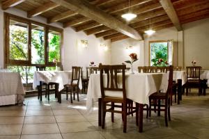 a dining room with white tables and chairs and windows at Casale Dell'Orso in Pistoia