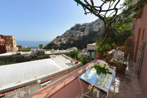a balcony with a table with flowers on it at Villa Maria Antonietta in Positano +14 photos