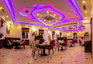 un restaurante con mesas y sillas y techo púrpura en Golden Plaza Hotel, en Tver