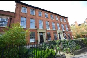 a brick building with a fence in front of it at Manchesters Ultimate House - Hot tub - Sleeps 23! in Manchester
