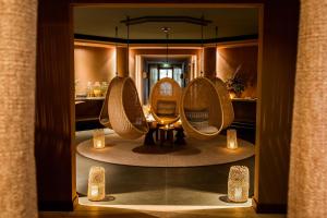 a room with three chairs in front of a mirror at Le Grand Bellevue in Gstaad