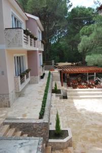 a courtyard of a building with a table and a patio at Hotel Art Media in Herceg-Novi