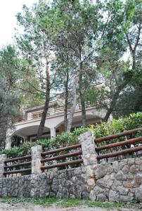 a stone retaining wall in front of a house at Hotel Art Media in Herceg-Novi