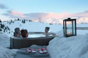 a group of people in a hot tub in the snow at Hamilton Lodge & Spa in Belalp