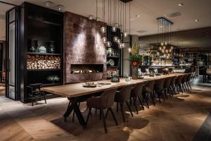 a long dining room with a long table and chairs at Van der Valk Hotel Apeldoorn in Apeldoorn