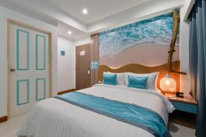 a bedroom with a large bed with a painting on the wall at T2 Jomtien Pattaya in Jomtien Beach